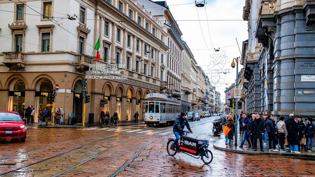 A tram and cyclist on a wet city street
