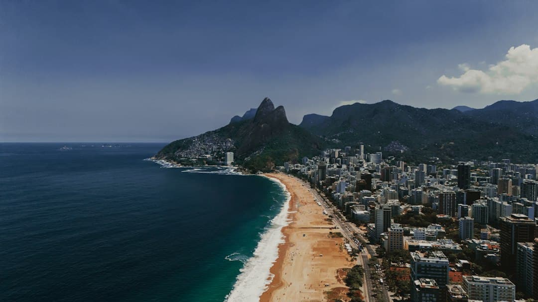 Coastal city with beach and mountains under blue sky