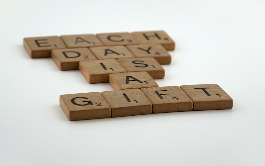 a group of scrabble tiles spelling each day as a gift