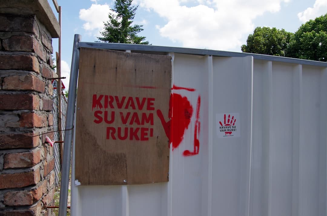 Red handprint and text on a fence