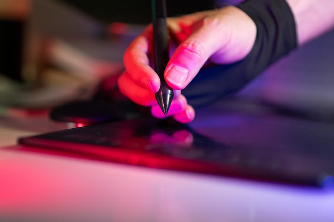 A person using a pen to write on a laptop