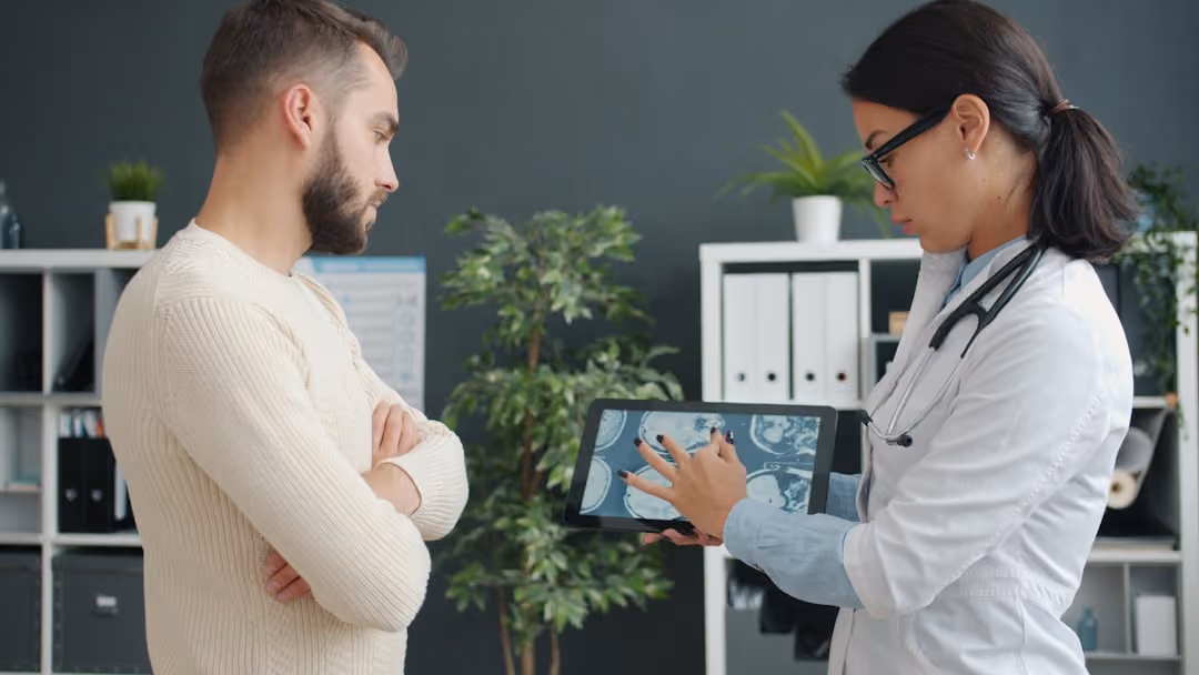 Doctor shows patient medical scan on tablet