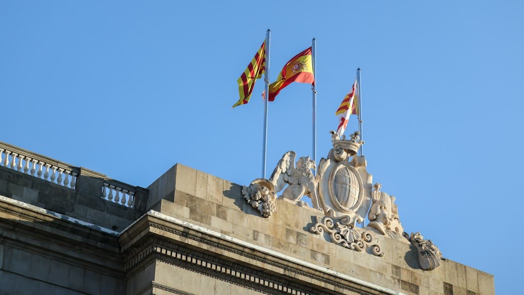 two flags are flying on top of a building